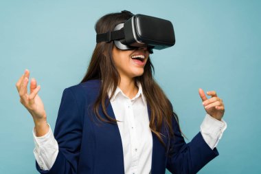 Cheerful young woman with a business suit smiling while having fun using virtual reality glasses
