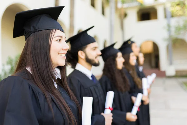 College Graduates Smiling Wearing Black Graduation Gowns Looking Happy While — Fotografia de Stock