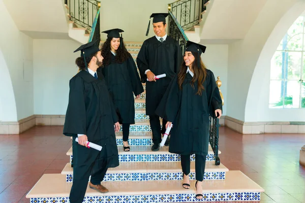 Счастливые Друзья Позирующие Лестнице Университетском Городке Выпускных Платьях Дипломах — стоковое фото