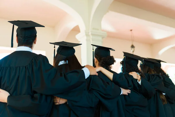Young Graduates Seen Hugging Line Wearing Graduation Gowns Caps University — Fotografia de Stock