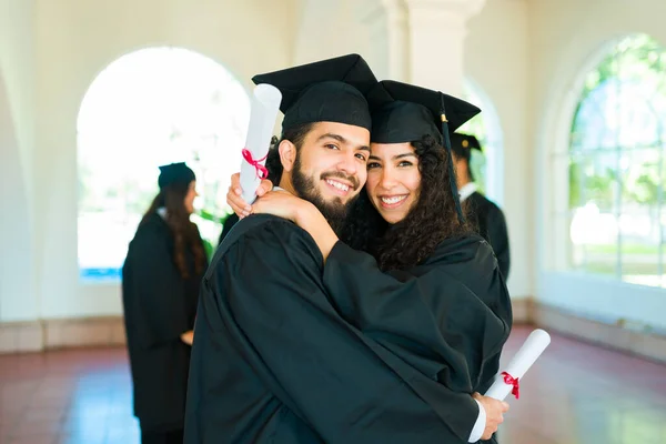 Portrait Attractive Couple Hugging Smiling Wearing Graduation Gowns Caps Graduation — Fotografia de Stock