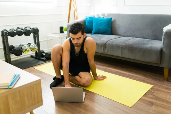 Latinské Fitness Muž Sedí Podložce Pomocí Svého Notebooku Sledovat Cvičení — Stock fotografie