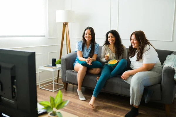 Happy Female Friends Laughing Eating Snacks While Relaxing Together Watching — Stok fotoğraf