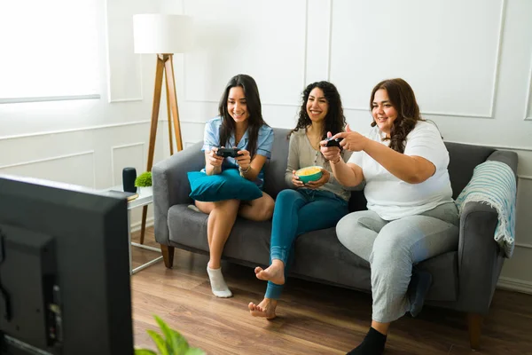Hispanic Female Friends 20S Laughing While Playing Video Games Pajamas — Stock Fotó