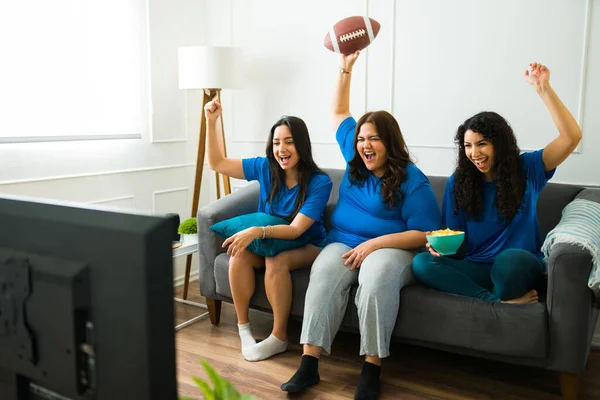 身着制服 在家里看电视足球赛的女性好友们欢呼庆祝 — 图库照片