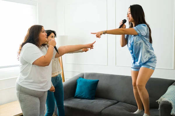 Hispanic Young Women Pajamas Having Fun Playing Karaoke Singing Music — Stok fotoğraf