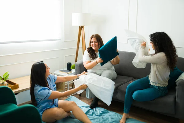 Hispanic Cheerful Best Friends 20S Sleepover Playing Pillow Fight Laughing — Stok Foto