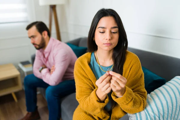 伤心的年轻女人在和丈夫在家里吵架后 一边想离婚 一边摘下结婚戒指 — 图库照片