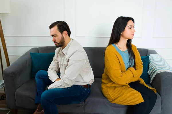 伤心欲绝的夫妻在争吵之后 一声不吭地坐在沙发上 背对着对方 对着自己的问题置之不理 — 图库照片