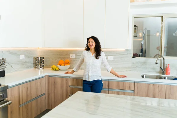 stock image Portrait of an attractive hispanic young woman enjoying her beautiful luxury granite kitchen looking happy 