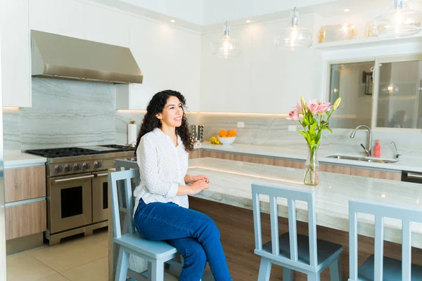 Attraktive Frau Sitzt Ihrer Inselküche Während Sie Entspannt Und Lächelnd — Stockfoto