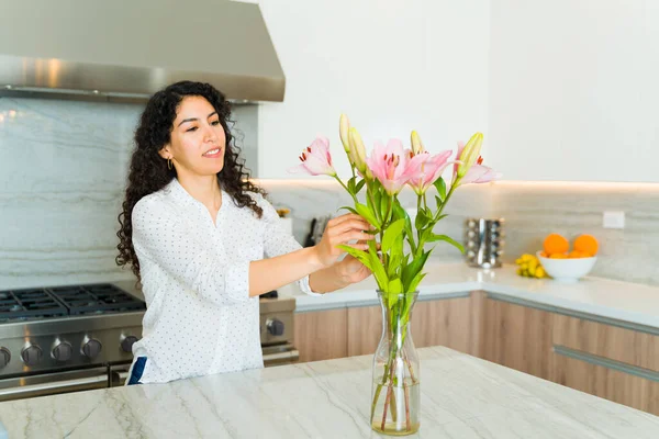 Mujer Joven Latina Sonriendo Mientras Pone Hermoso Arreglo Floral Cocina —  Fotos de Stock