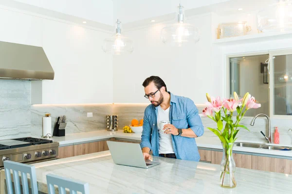 Attractive Caucasian Man Using His Laptop Drinking Coffee While Working — Stock Photo, Image