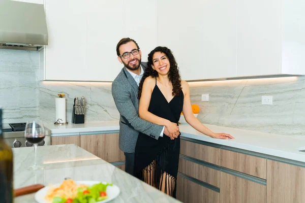 魅力的なカップルの肖像画は 自宅で夕食のための正式な服を着ている間にカメラを見て抱擁 — ストック写真