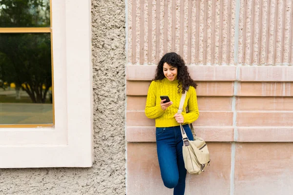 年轻女子在网上用手机发短信 上下班时用智能手机在城里放松一下 — 图库照片