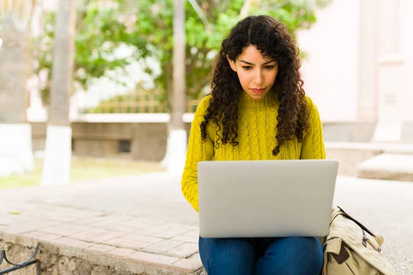 忙碌的年轻女性 卷发在笔记本电脑上打字 在户外做远程工作 — 图库照片