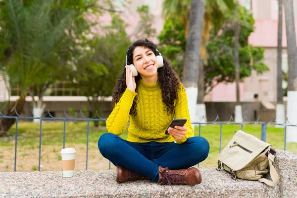 Gülümseyen Genç Kadın Parkta Akıllı Telefonu Kulaklığıyla Müzik Dinlerken Mutlu — Stok fotoğraf