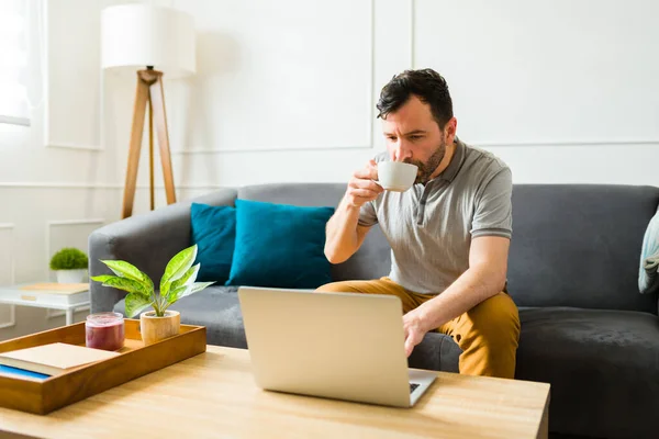 Caucasiano Bonito Homem Bebendo Café Enquanto Digita Laptop Fazendo Trabalho — Fotografia de Stock