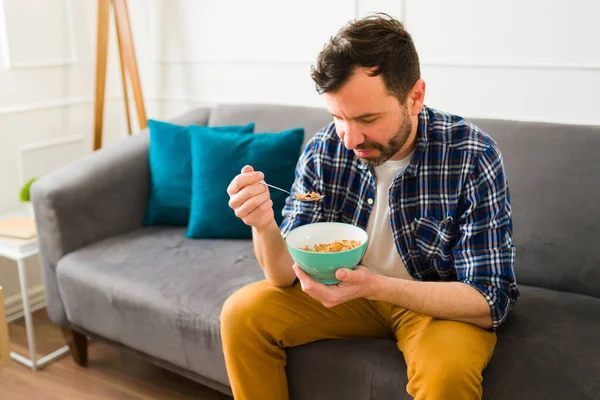 Relajado Hombre Casual Disfrutando Comer Cereales Mientras Está Sentado Sofá —  Fotos de Stock