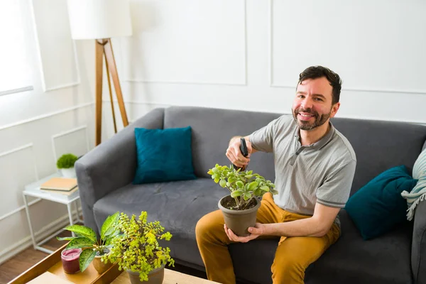 自宅で庭を楽しみながら植物に水をやりながら目を合わせる陽気な幸せな男の肖像画 — ストック写真