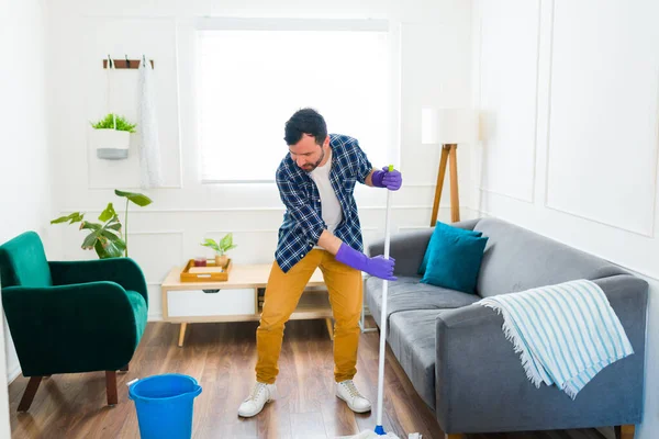 30多岁的白人男人在客厅里打扫地板 用拖把和清洁用品 — 图库照片
