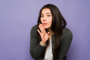 Güzel Asyalı bir kadının portresi elini ağzına koyar ve stüdyo arka planında bir sır ya da dedikodu anlatır.