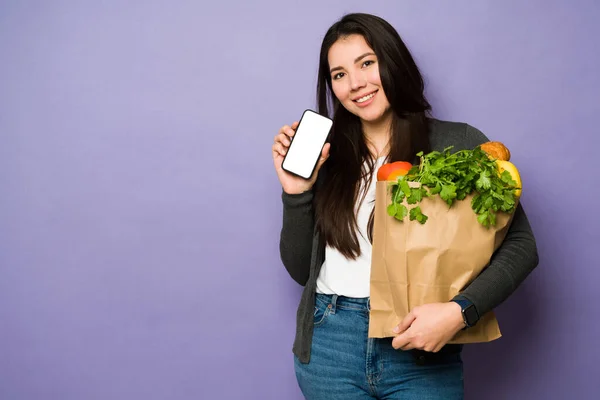 Çekici Asyalı Kadın Markette Poşet Taşırken Akıllı Telefon Ekranını Gösteren — Stok fotoğraf