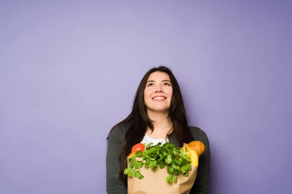 Mujer Feliz Pensativa Frente Fondo Púrpura Estudio Pensando Compras Comestibles — Foto de Stock