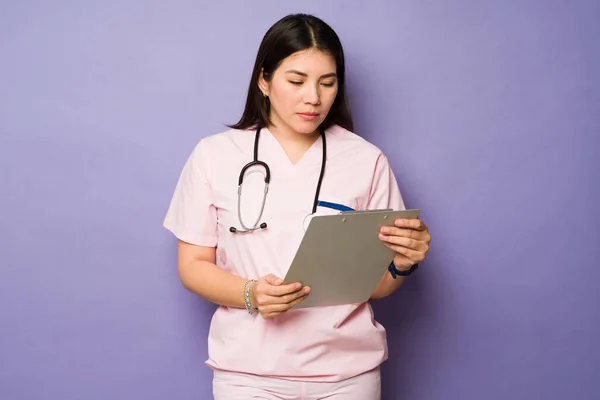 Branco Bela Enfermeira Vestindo Rosa Esfrega Olhando Para Registro Médico — Fotografia de Stock