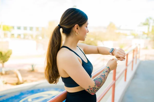 운동하기 자신의 스마트 워치와 사용하여 문신을 여성에게 행복하게 맞는다 — 스톡 사진
