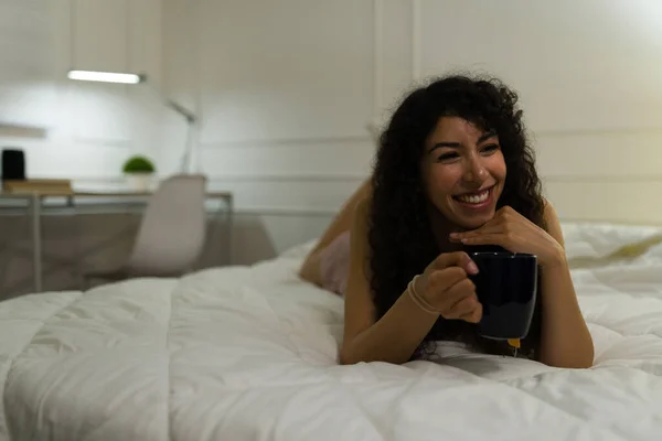 身穿睡衣的快乐女人笑着兴奋极了 晚上在卧室睡觉前轻松地喝茶 — 图库照片