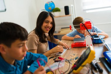 Heyecanlı genç kız gülerken robot sınıfı için elektronik aletler yaparken mutlu görünüyor.