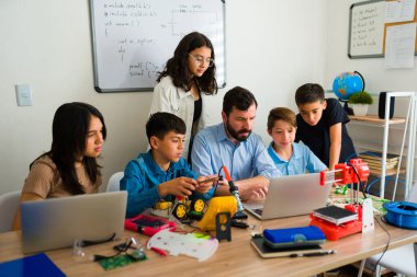 Akıllı gençler ve robotik öğretmen elektronik devreler ve prototipler oluştururken bilgisayarda kod yazmayı ve programlamayı öğreniyorlar.