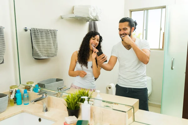 Podekscytowana Kobieta Mężczyzna Śmieją Się Pisząc Razem Smartfonie Myjąc Zęby — Zdjęcie stockowe