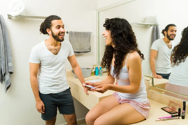 非常快乐的夫妇看起来很兴奋 在浴室里庆祝怀孕测试呈阳性 — 图库照片