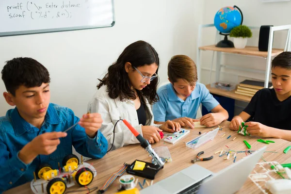 一緒にプロトタイプを構築しながら 学校の建物ロボットや電子回路で若い十代の若者のグループ — ストック写真