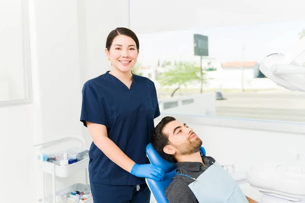 美丽的高加索女牙医在检查病人时微笑着 眼神交流 — 图库照片
