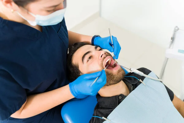 一个惊慌失措的男人和一个来牙医那里检查蛀牙的病人的高角度 — 图库照片
