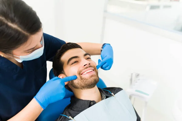 在清洁牙医的白牙和做牙科检查的同时 快乐迷人的男性患者微笑着 — 图库照片