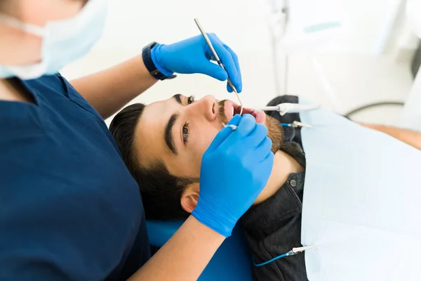 歯のクリーニングや虫歯治療のために来る歯科医でハンサムなヒスパニック系の男性と患者 — ストック写真
