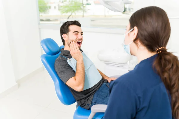 有魅力的西班牙男人 患有智齿牙痛 与女牙医交谈 — 图库照片