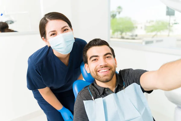 歯医者や診察後にパニックになる男性患者と一緒に自撮りする女性の個人的な視点 — ストック写真