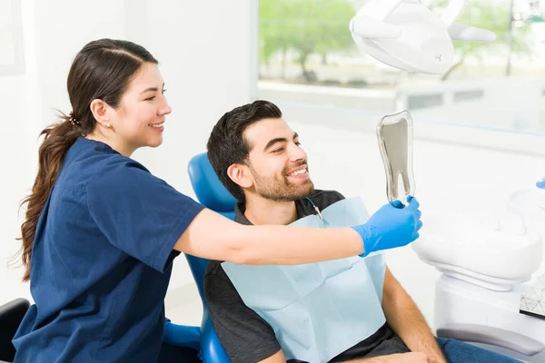 Захоплений Пацієнт Чоловічої Статі Дивиться Зуби Дзеркало Посміхається Після Відбілювання — стокове фото