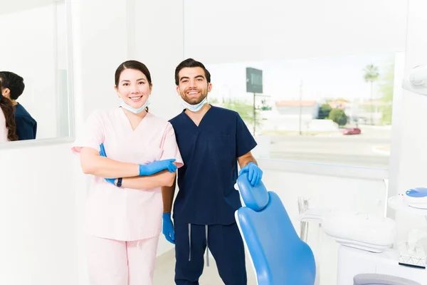 有吸引力的高加索女牙医和戴着刷子的男牙医助理准备好做病人检查 — 图库照片