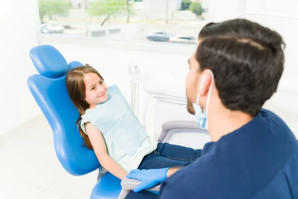 西班牙裔儿科牙医从后面看到一个漂亮的白人小孩来检查他的蛀牙 — 图库照片