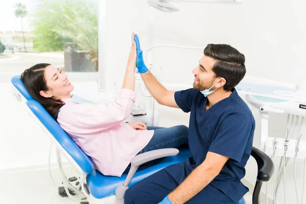 在完成牙齿矫正治疗后 兴奋的男牙医和高个子女病人看上去很开心 — 图库照片