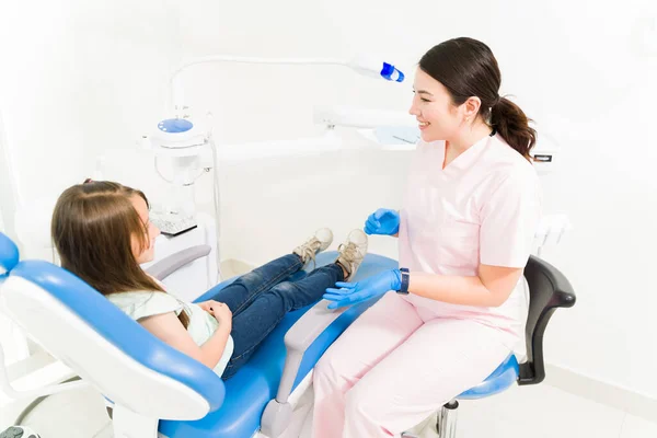 愉快的儿科牙医与来办公室接受牙科治疗和蛀牙检查的儿童病人交谈 — 图库照片