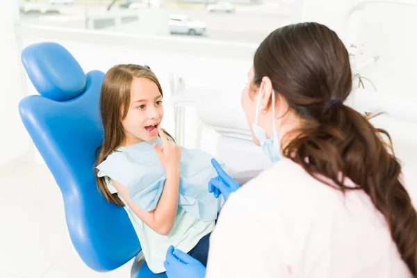 Urocza Dziewczynka Pokazująca Zęby Dziecku Dentyście Pediatrii Wskazująca Jej Uśmiech — Zdjęcie stockowe