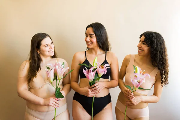 Счастливые Разнообразные Три Женщины Держащие Цветы Чувствующие Себя Женственными Счастливыми — стоковое фото