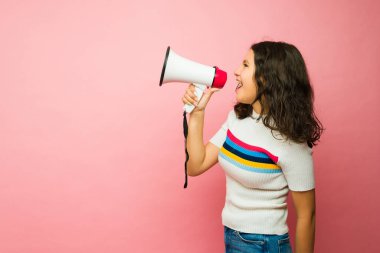 Pembe fotokopi alanının yanındaki protesto sırasında megafonla bağıran öfkeli İspanyol genç kız.